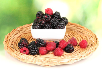 Ripe raspberries and brambles on nature background