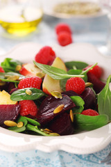 Fresh vegetarian salad with beets, apples and raspberries.