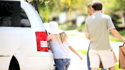 Young Caucasian Family Packing Car Before Outing