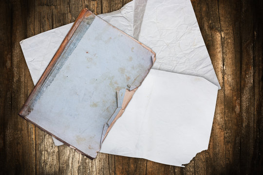 Torn book and papers on wood
