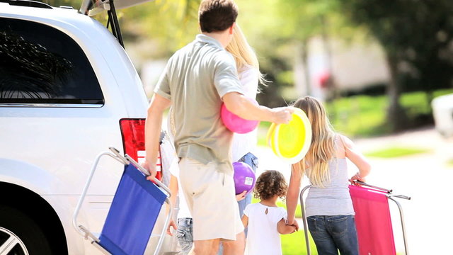 Young Family Packing Car for Trip to Beach