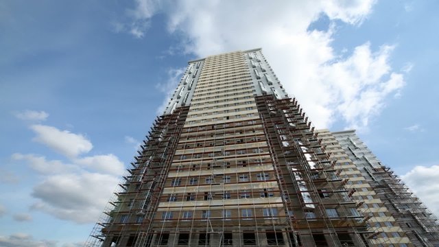 Under construction skyscraper stands against sky