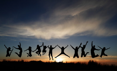 silhouette of kids jumping on beach in sunset © Alex Koch