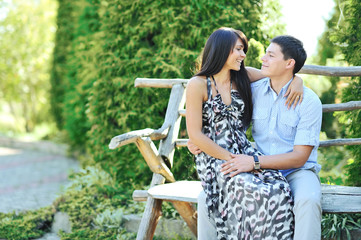 Naklejka premium Portrait of happy young couple smiling while sitting together
