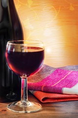 Glass and bottle of red wine. Rustic design.