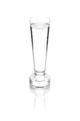 shot glass filled with clear cold alcohol isolated on white