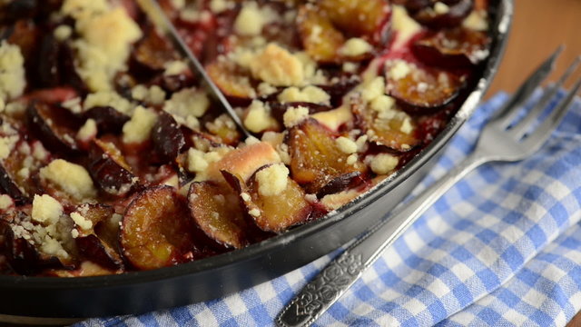 Pflauemkuchen wird in Kuchenst&uuml;cke geschnitten