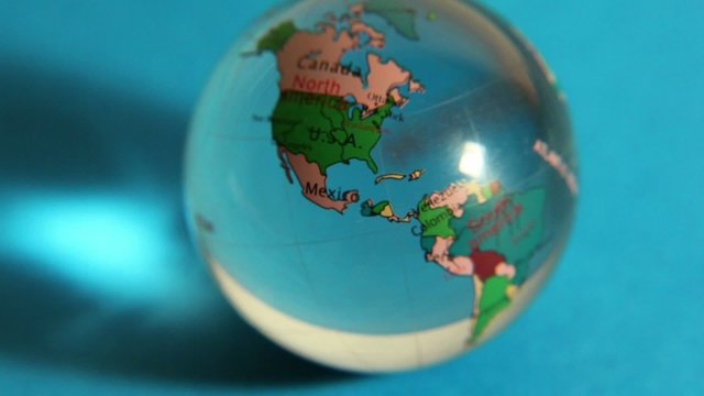 Loupe magnifies transparent sphere with world map on it