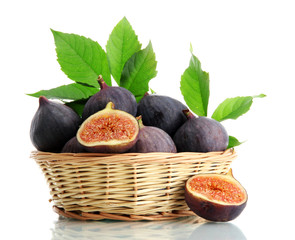 Ripe sweet figs with leaves in basket isolated on white
