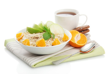 tasty oatmeal with orange and apple, cup of tea, isolated