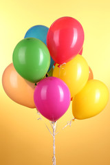Colorful balloons on yellow background