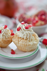 Little cakes with cream and pomegranate