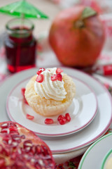 Little cakes with cream and pomegranate