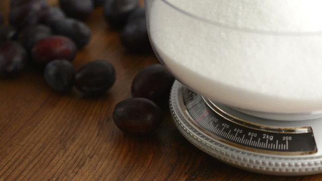 Pflaumen rolle aus Tisch mit K&uuml;chenwaage und Zucker