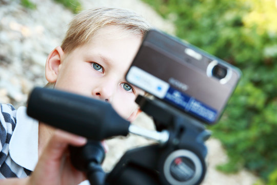 Young operator. The young boy with camera like movie maker.