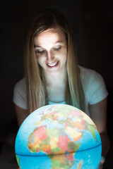 Frau hällt erleuchteten Globus
