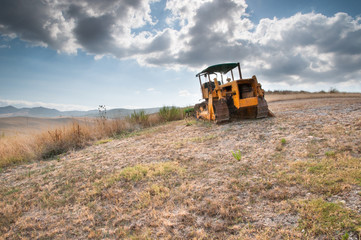 Naklejka premium Bulldozer in a Tuscan hill
