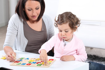 Mother and daughter completing a letter puzzle