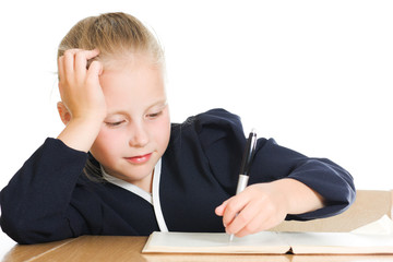 Schoolgirl writes at a table