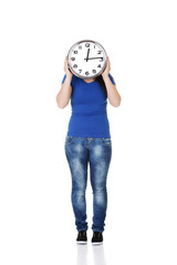 Happy young woman holding office clock