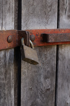 Old bar lock hanging on wooden doors