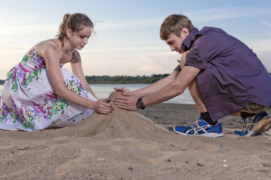 The guy and the girl fill a heap of sand
