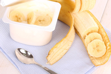yogurt with banana on wooden background