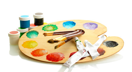 wooden art palette with paint and brushes isolated on white