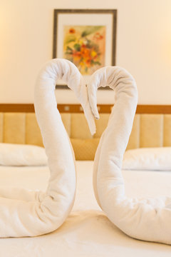 A Couple Of Fake Swan Made Of Towel On The Hotel Bed