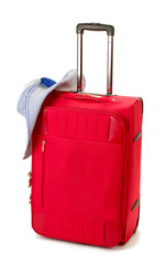 Red suitcase with woman's hat isolated on white