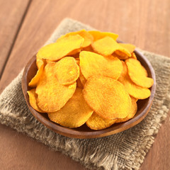 Crispy Peruvian sweet potato chips on wooden plate