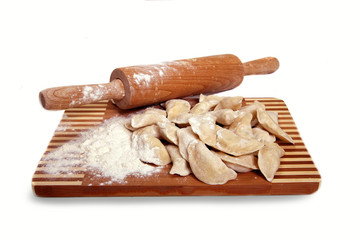 Raw Dumplings on cutting board on wooden background close-up