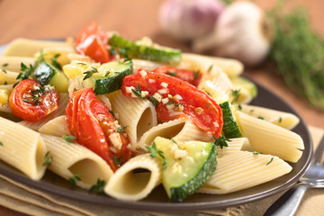 Vegetarian pasta dish with baked zucchini and tomato