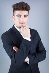 Portrait of a handsome young business man on grey background