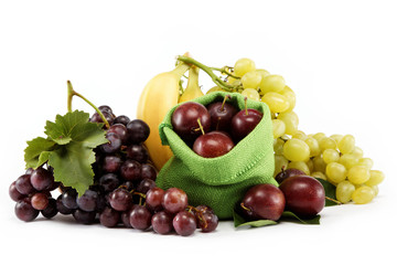 Plums and a bunch of grapes isolated against white background.