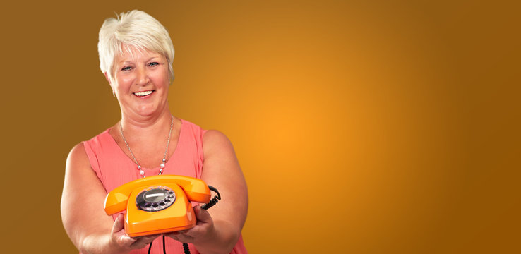 Portrait Of A Senior Woman Holding A Retro Phone