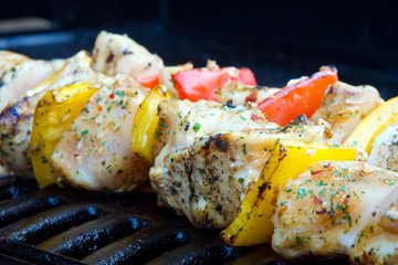 chicken and pepper kebabs slowly cooking on the barbecue