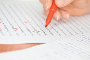 Hand with Red Pen Transcribing a Story