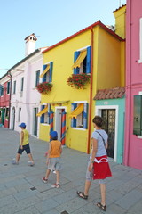 family that walks in the midst of colorful houses on the island