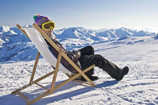 Jeune femme dans une chaise longue sur les pistes de ski - Alpes