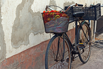 Old rusty bicycle with colorful peppers in basket