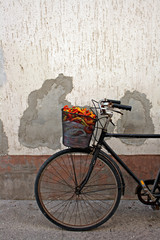 Naklejka premium Old rusty bicycle with colorful peppers in basket