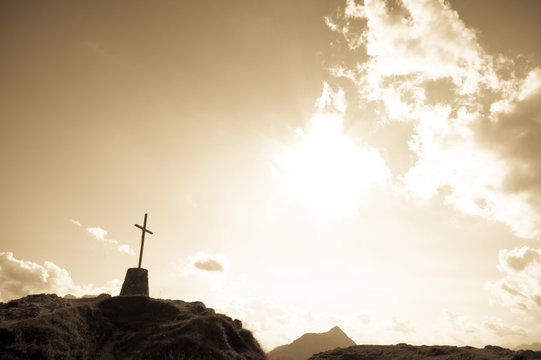 Dramatic sky scenery with a mountain cross