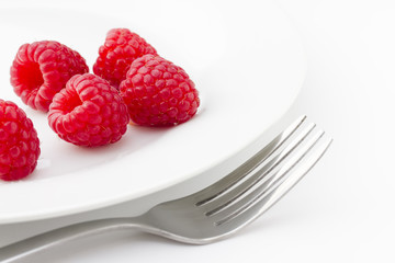 Ripe red raspberries on plate