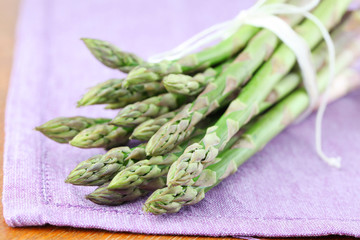 Green asparagus on purple napkin