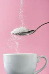 Pouring sugar in coffee cup