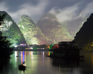 Night image of Yangshuo city near cloudy hill. Long exposure