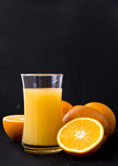 Orange and orange juice on a dark background