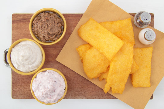 polenta fritta con salse su tavolo bianco