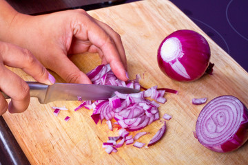Chopping red onion on the kitchen cutting board © Patryk Kosmider